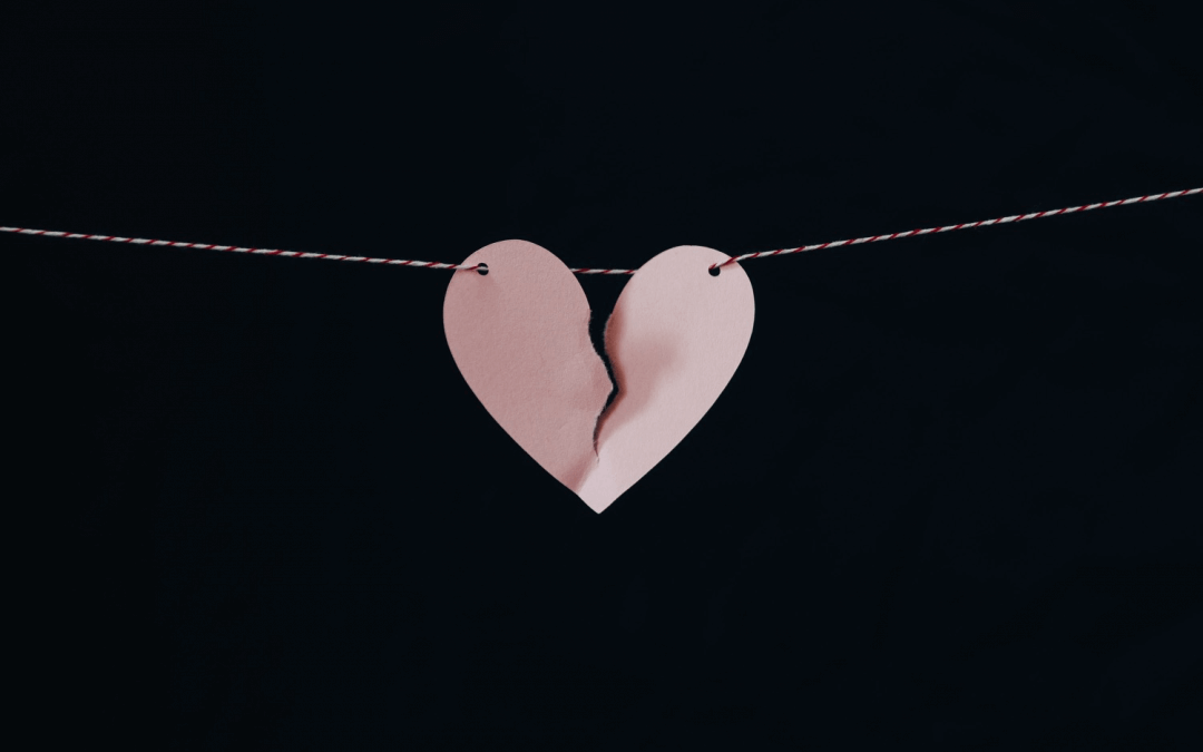 a paper heart with a broken piece of paper attached to a string